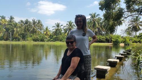 a woman standing next to a woman in the water at Priyanna Guest, Forest view in Polonnaruwa