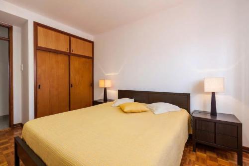 a bedroom with a bed with two pillows and two lamps at Charming Spacious House - In The Heart Of The City in Viana do Castelo