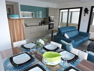 Una sala de estar con una mesa y un sofá azul. en Plage Propriano 4 étoiles, en Propriano