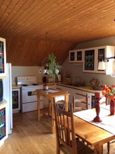 Ayers Cliff的住宿－La Maison Pamaljolie，厨房设有木桌和木制天花板。