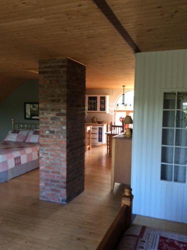 La Maison Pamaljolie في Ayers Cliff: غرفة مع عامود من الطوب في منتصف المنزل