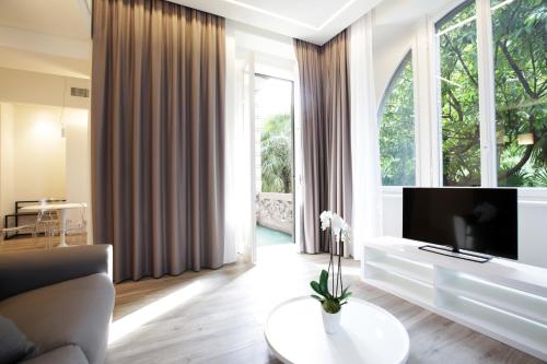 a living room with a tv and a large window at Villa Liberty in Como