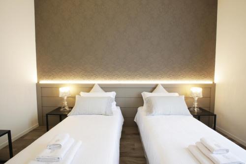 two beds in a room with white sheets at Villa Liberty in Como