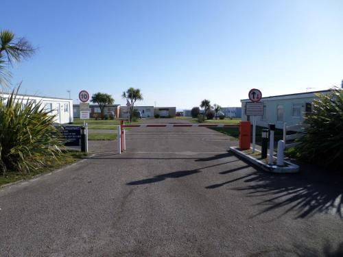 a parking lot with street signs and palm trees at Lighthouse Chalet in Lowestoft