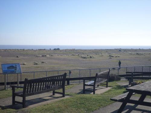 a group of benches sitting in front of a field at Lighthouse Chalet in Lowestoft