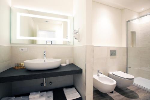 a bathroom with a sink and a toilet and a mirror at Villa Liberty in Como