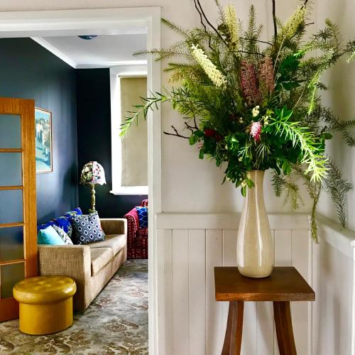 a living room with a vase of flowers on a table at Vine Valley Inn in Cessnock