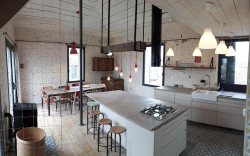 a kitchen with a counter and a table and chairs at La Terrasse La Tremblade in La Tremblade