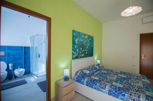 una camera con letto e un bagno con doccia di Sandalia B&B a Lotzorai