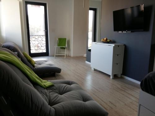 a living room with two couches and a flat screen tv at Le Manoir de Champlan in Grimisuat
