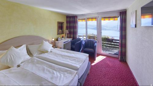 Habitación de hotel con cama y balcón en Hotel Restaurant Panorama en Aeschlen