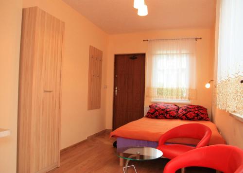 ヴィスワにあるWilla Wisełkaのベッドルーム1室(ベッド1台、赤い椅子2脚付)