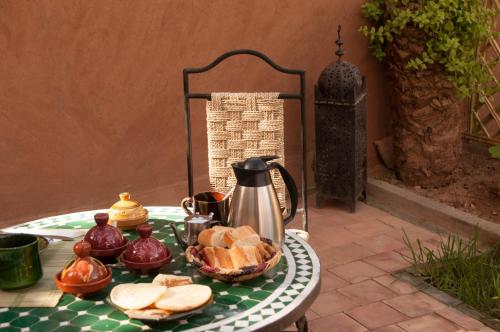 a table with a tea kettle and bread on it at Dar Sofar in Agdz