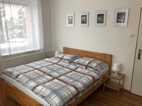 a bedroom with a bed with a plaid blanket at Pension Na Vyhlídce in Český Krumlov