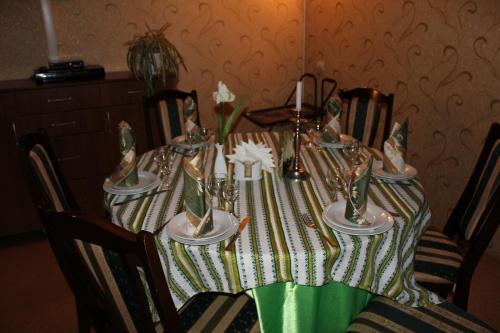a dining room table with a green and white table cloth at Galant Hotel in Boryspilʼ