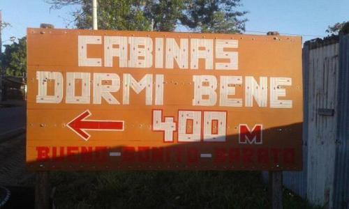 Ein orangenes Schild, auf dem steht, dass Detroit Trommeln Trommeln Trommeln, Trommeln nach links abbiegen in der Unterkunft Cabinas Dormi Bene in Miramar