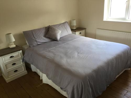 a bedroom with a bed with two night stands and a window at Westport Holiday Home in Westport