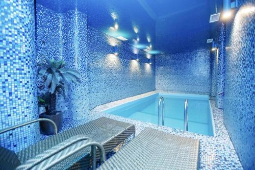 Baño azul con bañera con mesa y banco en Green House Hotel Tyumen, en Tyumen