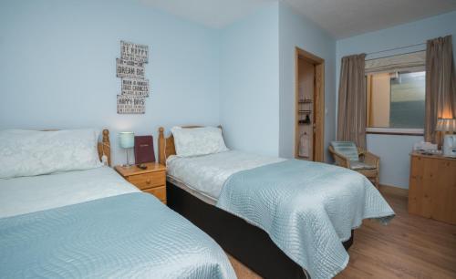 een hotelkamer met 2 bedden en een raam bij The Gap Lodge B&B in Donegal