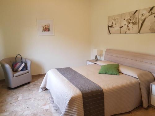 a bedroom with a bed and a chair at Villa Lorenzo primo piano in Camaiore