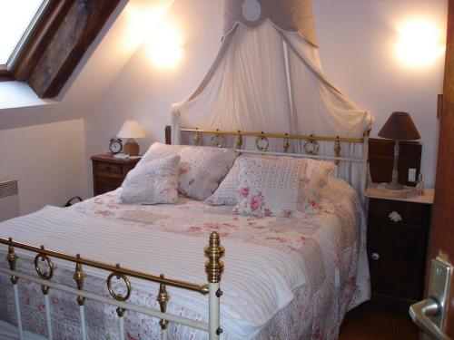 a bedroom with a large bed with a canopy at Chez Marraine in Sauvat