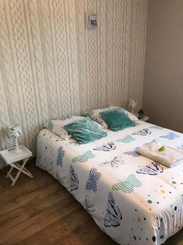 Cama con sábanas y almohadas azules y blancas en Les Lilas Roses, en Chamouilley