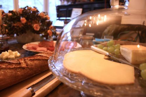 a table with cheese and bread and a glass bowl at Casa Lucinda in Ghent