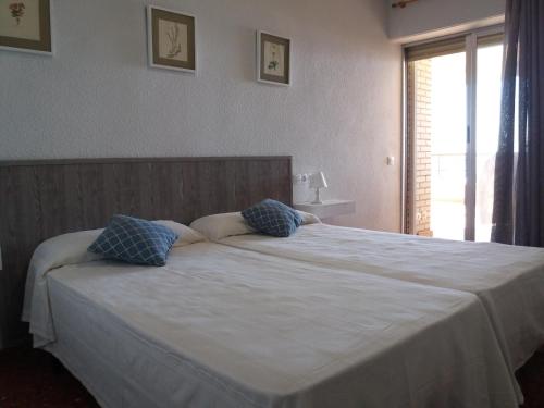 オロペサ・デル・マールにあるEdificio Las Rocasのベッドルーム(青い枕の大きな白いベッド付)