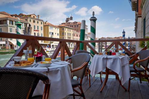 a table with plates of food on a balcony at Canal Grande in Venice