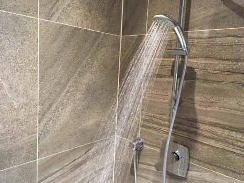 a shower with a shower head in a bathroom at Pension Karnet in Prague