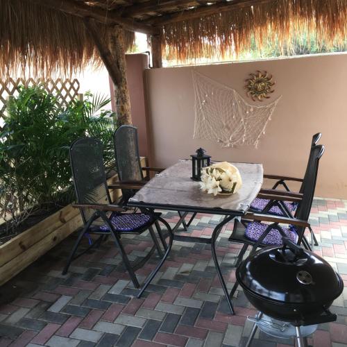 a table with chairs and a cat statue on it at Villa Unique in Willemstad