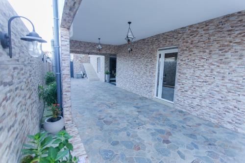 a brick building with a stone walkway next to a building at Résidence Hôtelière Le Jomonia in Libreville