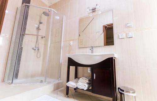 a bathroom with a sink and a shower at Résidence Hôtelière Le Jomonia in Libreville