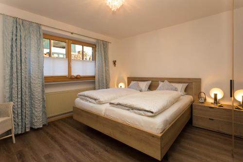a bedroom with a large bed and a window at Ferienwohnung Mitteldorf in Oberammergau