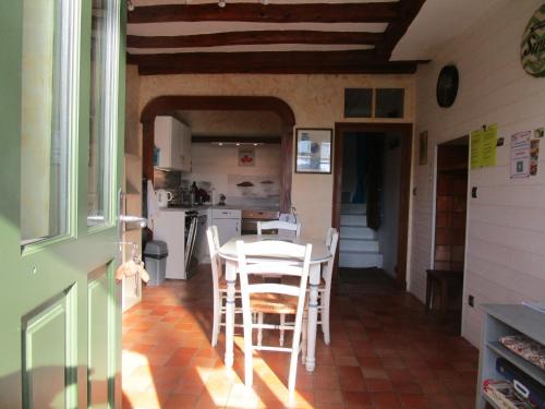 cocina y comedor con mesa y sillas en Gîte Le Bourgneuf en Fresnay-sur-Sarthe