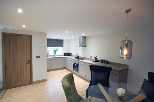 a kitchen with a table and chairs in a room at Meadowsweet Cottage, Drift House Holiday Cottages in Astbury