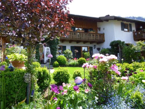 a garden in front of a house with flowers at Ferienwohnung Mitteldorf in Oberammergau