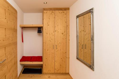 a room with a wooden closet and a mirror at Chalet la cordée in Bettmeralp