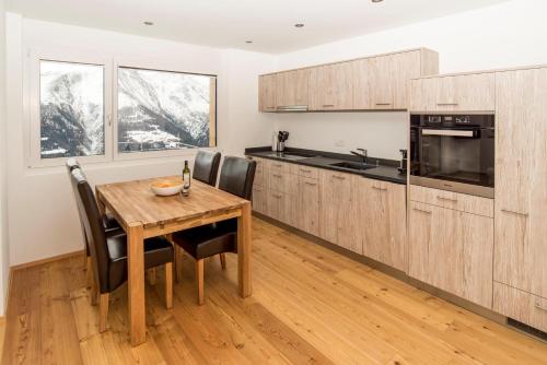 a kitchen with a wooden table and some chairs at Chalet la cordée in Bettmeralp