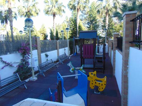 a playground with benches and palm trees at Apartamentos varios con 2 dorm en Marina Dor , la playa de Amplaries 47 , vista lateral al mar in Oropesa del Mar