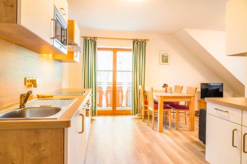 a kitchen with a sink and a table with chairs at Hansalagut in Mauterndorf