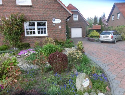 a garden in front of a brick house at Haus Mühlenblick Luftkurort Werdum in Neuharlingersiel