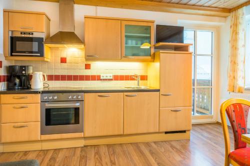 a kitchen with wooden cabinets and a stove at Hansalagut in Mauterndorf
