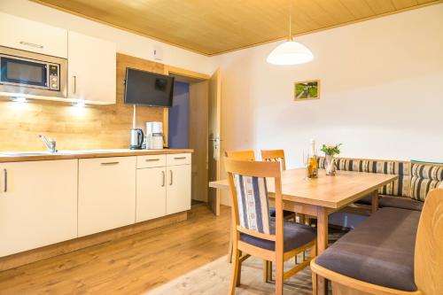 a kitchen and dining room with a wooden table and a kitchen and a dining room at Hansalagut in Mauterndorf