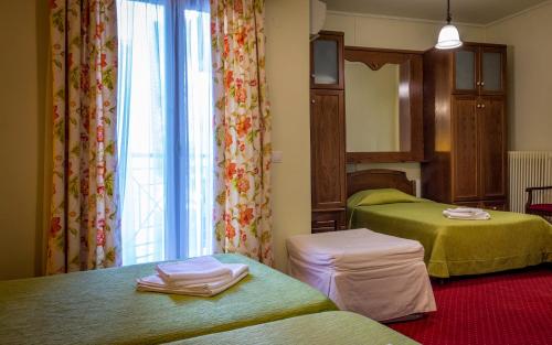 a hotel room with two beds and a window at City Hotel Apollonion in Karpenision