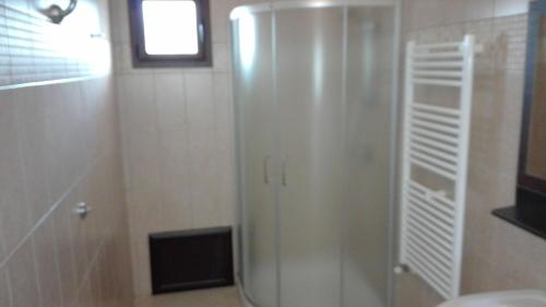 a shower with a glass door in a bathroom at Casa la rosa dei venti in Cardedu