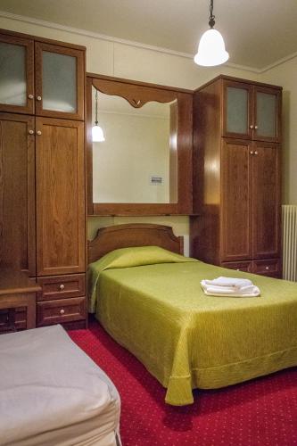 a bedroom with two beds and wooden cabinets at City Hotel Apollonion in Karpenision