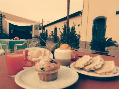 a table with two plates of food and two drinks at Villa Laura Apartment in Giardini Naxos