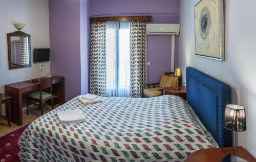 a hotel room with a bed and a desk at City Hotel Apollonion in Karpenision