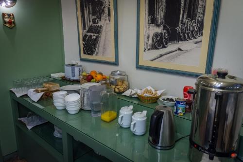 a green counter with plates and cups on it at City Hotel Apollonion in Karpenision